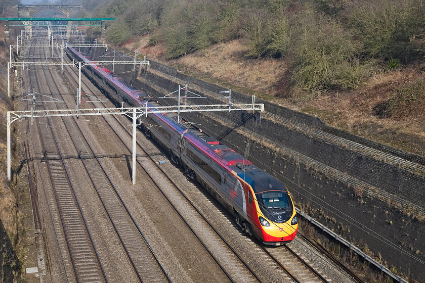 390122, 08.42 Oxley-London Euston ECS (5A16), Roade cutting 
 With the fog now having lifted and strong welcome winter sun coming through 390122 'Penny the Pendolino' heads through Roade cutting on the up slow line working Virgin's 08.43 Oxley to Euston Sunday only ECS move. This is a regular Sunday move that up until last year was a locomotive hauled 'drag' by a Class 57. 390122 was the first Pendolino to rack up one million miles in service back in 2008 an event that took place close to here just south of Bletchley. 
 Keywords: 390122 08.42 Oxley-London Euston ECS 5A16 Roade cutting Virgin Pendolino Penny the Pendolino