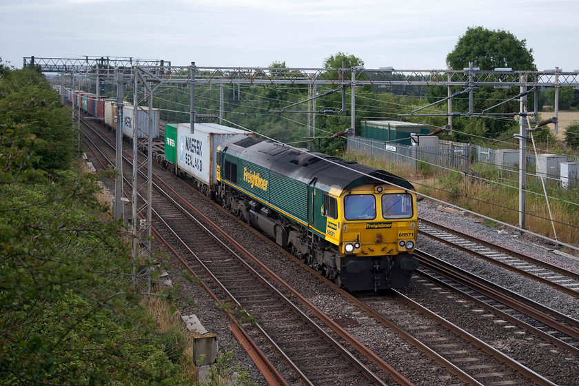 66571, 04.25 Felixstowe North-Lawley Street (4M88), Hungate End SP784465 
 The 4M88 04.25 Felixstowe North to Lawley Street Freightliner approaches Hungate End between Wolverton and Hanslope Junction with 66571 in charge. 
 Keywords: 66571 04.25 Felixstowe North-Lawley Street 4M88 Hungate End SP784465