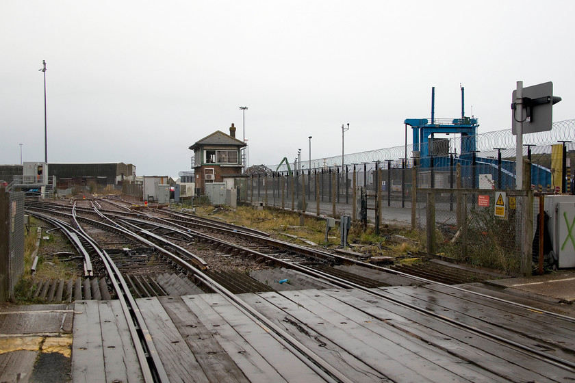 Newhaven Harbour level crossing & signal box 
 With just three weeks left in operation, the signal box and level crossing at Newhaven Harbour are seen. The Seaford branch continues off to the left in this image with the double track line becoming single just around the curve. The lines straight ahead, past the box, are the short spur that terminates next to the closed Newhaven Marine station. These are to see future use carrying freight into the harbour complex. 
 Keywords: Newhaven Harbour level crossing signal box