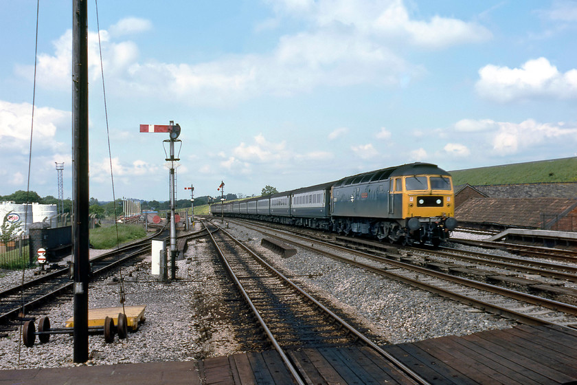 47508, 13.30 London Paddington-Paignton (1B84), Tiverton Junction station 
 47508 'Great Britain' passes Tiverton Junction leading the 13.30 Paddington to Paignton service. The station was a grand affair that once was a junction for the branches to Hemyock, Tiverton itself and Dulverton. It also had an oil depot seen in this photograph that was rail linked, but I never actually witnessed any trains accessing it. The huge grass bank in the background has the M5 motorway running along the top of it. 47508 was named the previous year at Old Oak Common and was renamed as part of the GWR 150 celebrations in 1985 becoming the similarly named 'SS Great Britain'. 
 Keywords: 47508 13.30 London Paddington-Paignton 1B84 Tiverton Junction station Great Britain