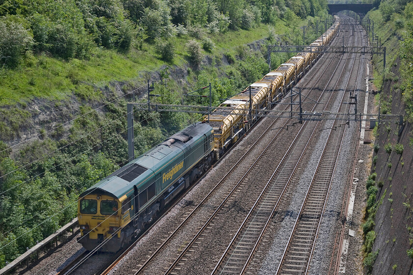 66523, 08.45 High Oaks Junction-Willesden Euroterminal (6Y15), Roade cutting 
 Working hard at the rear of the 08.45 High Oaks Junction to Willesden Euroterminal 66523 is seen passing through Roade cutting. The length and the weight of the high output ballast cleaner (HBOC) train requires two locomotives with even those being somewhat challenged given the speed that the train was going at that I would have estimated to be twenty miles per hour. 
 Keywords: 66523 08.45 High Oaks Junction-Willesden Euroterminal 6Y15 Roade cutting Freightliner