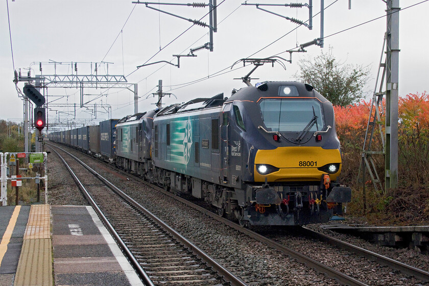 88001 & 88006, 12.16 DIRFT-Mossend (4S44, 7E), Winsford station 
 It was worth the wait! I had been tracking the progress of the 4S44 12.16 Daventry to Mossend knowing that it was usually double-headed and was pleased when it passed with 88001 'Revolution' as it was a photographic cop. With 88006 'Juno' assisting the pair are seen making good progress past Winsford station with a long and well-loaded train. 
 Keywords: 88001 88006 12.16 DIRFT-Mossend 4S44 Winsford station DRS Direct Rail Services Revolution Juno