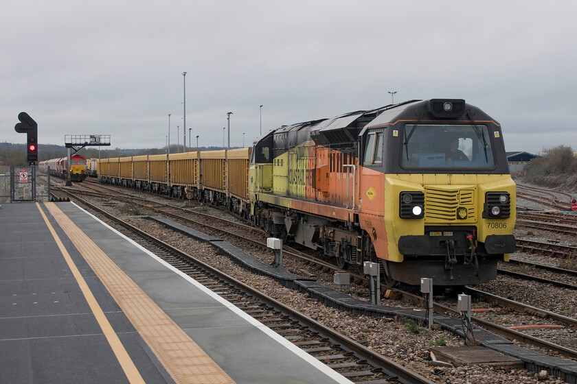 70806, 11.42 Westbury Down-Cliffe Hill Stud Farm (6M40, 97E) & 59205, 11.23 Merehead-Wootton Bassett (7B12, 15L), Westbury station 
 70806 negotiates its way out of Westbury's Yard leading the 7B12 empty wagon service to Cliffe Hill Stud farm in Leicestershire. The train is composed of a rake of Polish built IOA (E) box wagons nicknamed mussels that have a capacity of just over one hundred tons. In the background 59205 waits patiently to continue also eastwards with the 11.23 Merehead to Wootton Basset stone train. 
 Keywords: 70806 11.42 Westbury Down-Cliffe Hill Stud Farm 6M40 59205 11.23 Merehead-Wootton Bassett 7B12 Westbury station Colas Rail