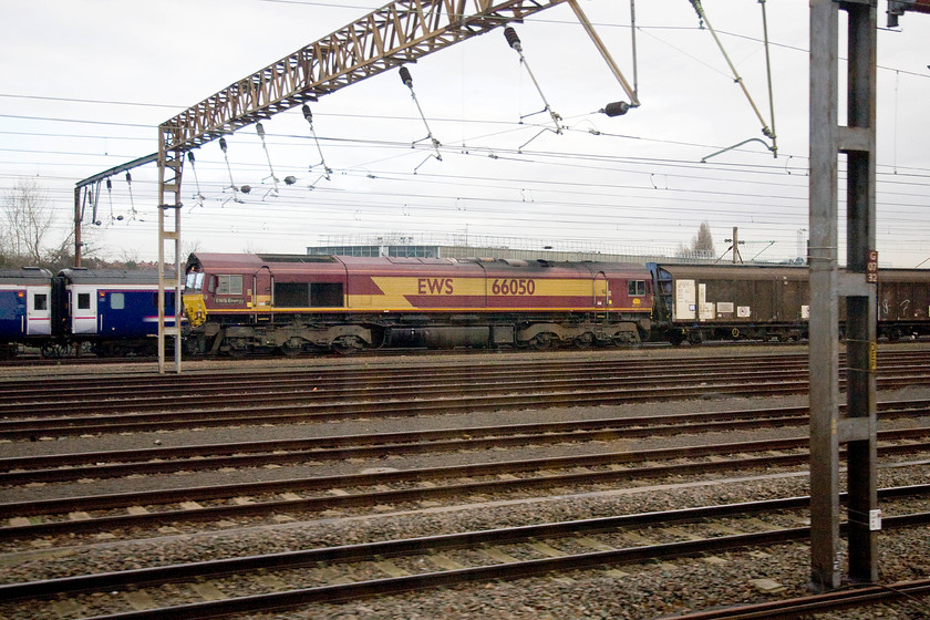 66050, stabled, Wembley yard 
 66050 'EWS Energy' sits at the head of what looks to be the 6M44 Dollands Moor to Daventry water bottle train. It is seen in Wembley yard with the stabled sleeper stock behind. 
 Keywords: 66050 stabled Wembley yard