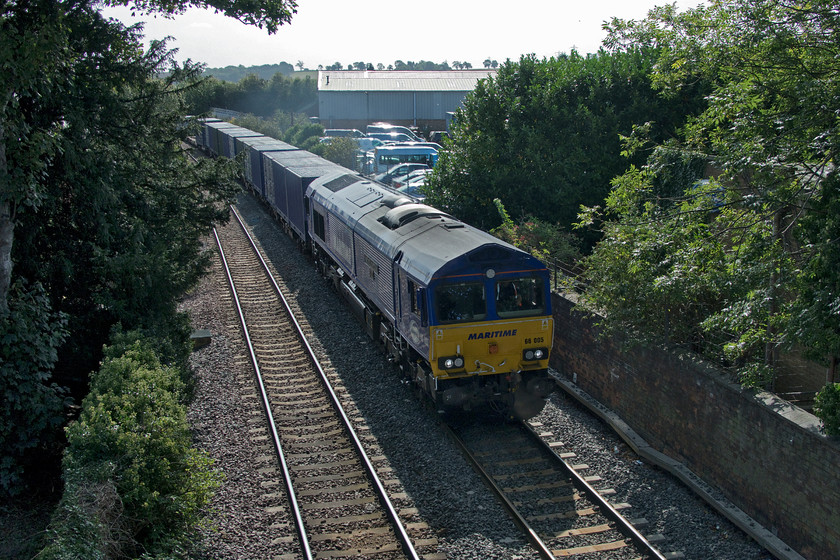 66005, 08.00 Felixstowe South-East Midlands Gateway (4M79, 92L), Oakham level crossing 
 I was pleased to see a posting that the heavily delayed 08.00 Felixstowe South to East Midlands gateway 4M79 Freightliner was hauled by a Maritime loco. so I was prepared for its passing at Oakham despite the awful positioning from the level crossing footbridge. I was hoping for any one of the four Maritime Class 66s that I have yet to photograph (66047, 66051, 66148 and 66163) but was disappointed that it was 66005 'Maritime Intermodal One' that appeared around the corner - again! I have many pictures of this one at various locations, for example..... https://www.ontheupfast.com/p/21936chg/26772584804/x66005-04-11-wakefield-europort-didcot 
 Keywords: 66005 08.00 Felixstowe South-East Midlands Gateway 4M79 Oakham Maritime Maritime Intermodal One