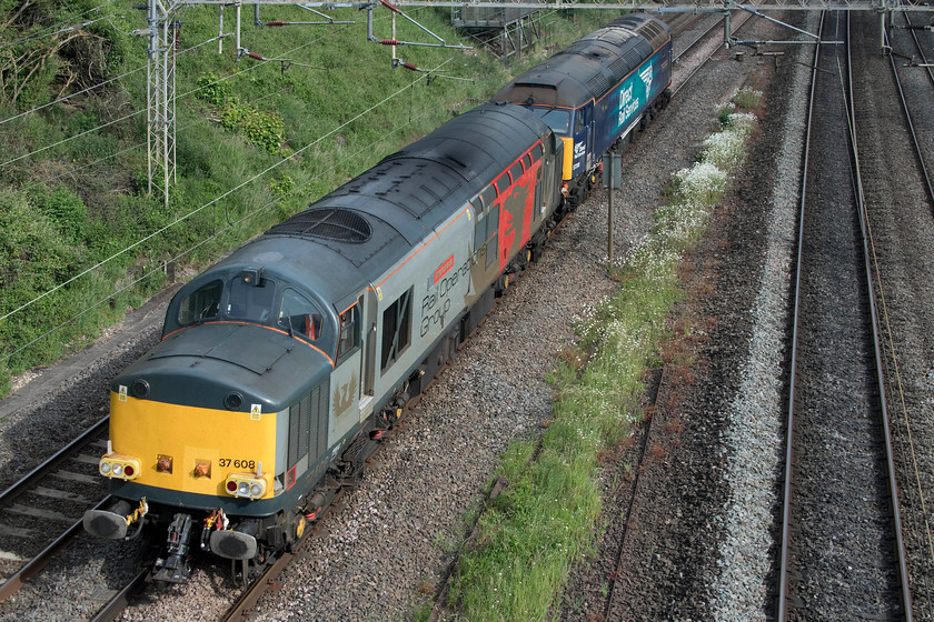 37608 & 57310, 15.49 Willesden TMD-Leicester LIP (0M59, 23E), Victoria bridge 
 Having been involved in the transfer of 710130 from Old Dalby to Willesden earlier in the day (via the MML, Marston Vale and WCML) 37608 'Andromeda' and 57310 'Pride of Cumbria' head back to Leicester. The duo is seen about to pass under Victoria bridge just a short distance south of Roade as the 0M59 15.49 Willesden to Leicester LIP. 
 Keywords: 37608 57310 15.49 Willesden TMD-Leicester LIP 0M59 Victoria bridge Andromeda Pride of Cumbria