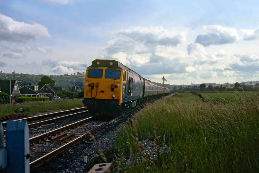 50034, unidentified up working, Stoke Canon Crossing 
 This was another example of a photograph that was originally confined to the rejects' box back in 1980. However, on revisiting it and with new technology at my fingertips, I decided to have a go at resurrecting it. I actually really like the image, particularly the sky, that shows 50034 'Repulse' leading an unidentified up working. I can find no information as to what this service was but being composed of a rake of Mk.1 stock I suspect that it was not heading for Paddington. If anybody can advise I would appreciate some suggestions. The train is seen passing Stoke Canon taken looking south-west from the level crossing. 
 Keywords: 50034 unidentified up working Stoke Canon Crossing Furious