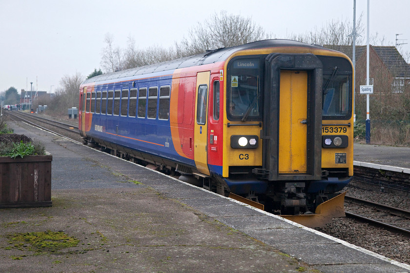 153379, EM 10.40 Peterborough-Lincoln (2K38, 3E), Spalding station 
 A misty and grey winter scene at Spalding station. East Midlands 153379 arrives working the 10.40 Peterborough to Lincoln. I have visited Spalding station several times, and every time it has lost just a little more of its old Great Northern character. Now the semaphores and the fantastic box, that was situated on the level crossing in the background, have gone it's a bit barren and bare. 
 Keywords: 153379 2K38 Spalding station