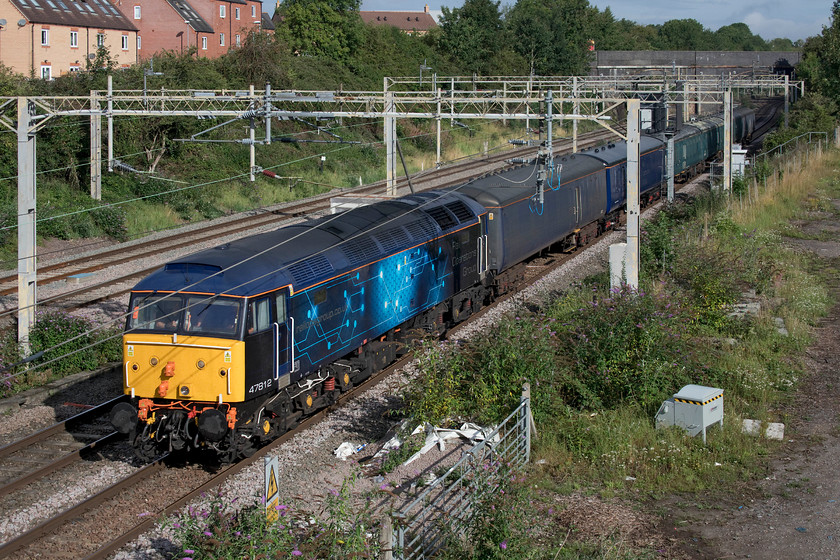 47812, 05.41 Chaddesden sidings-Wolverton Centre sidings (5H70, 5L), site of Roade station 
 I had been tracking the progress of this 5H70 working from Derby to Wolverton for an hour or so and was determined to get out and see it as it was such a lovely morning. Postings indicated that it had five barrier coaches in tow so I judged that it would just fit in this view at the site of Roade's former station. Looking very smart in its Rail Operations Group livery, 47812 approaches the end of its journey to Wolverton conveying the barriers - a little later involved in the repatriation of a Class 442 back to Eastleigh after refurbishment. I have a picture of this particular Class 47 taken much earlier in its life back in 1977 at Bradford-on-Avon when it was running as 47239, see..... https://www.ontheupfast.com/p/21936chg/23615754404/whilst-waiting-for-our-train-to 
 Keywords: 47812 05.41 Chaddesden sidings-Wolverton Centre sidings 5H70 site of Roade station ROG Rail Operations Group