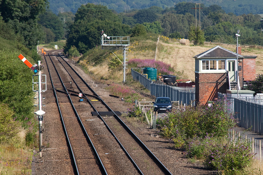 Dorrington signal box (LNW & GW joint, c.1872) 
 Taken from the road bridge to the south of the site of the old station (closed 09.06.58) Dorrington signal box is seen. The box was constructed is a Type 1 LNW/GW joint design built c.1872 containing a 33 lever frame. Notice the mixture of upper and lower quadrant arms consummate with the box's heritage. When I last visited in 1981, I was able to take a picture standing on the loop that ran in the space to the right of the present day running lines. I would have been standing approximately just in front of the signallman's 2009 Ford Focus. Either the box was switched out and I ventured trackside or or the signalman on-duty permitted me access. My notes do say that the box had a wooden nameboard that I believe is still fitted today and that I saw the 1M84 11.50 Cardiff to Crewe working with an unidentified class 33. 
 Keywords: Dorrington signal box