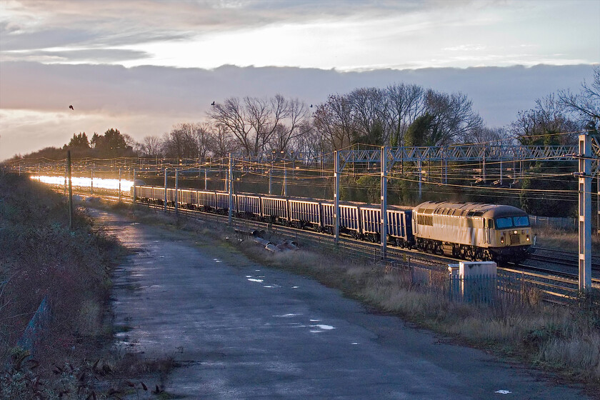 56301, 07.29 Wembley Yard-Burton-ot-Wetmore Junction (6Z45, 8E), site of Roade station 
 I had not picked up the running of this 6Z45 spoil train until serial poster Chris Warman mentioned that it was sitting in Wembley Yard ready to run in one of his UKRail posts. As the sun was actually putting in an all too brief appearance I popped out from home to capture it passing through Roade. 56301 is seen leading the 07.29 Wembley to Burton-ot-Wetmore Junction made up of a loaded rake of smart JMA/MMA aggregate box wagons. Notice the extreme glint from a southbound Pendolino towards the rear of the train and the three crows startled no doubt by the noise of the Grid! 
 Keywords: 56301 07.29 Wembley Yard-Burton-ot-Wetmore Junction 6Z45 site of Roade station Grid