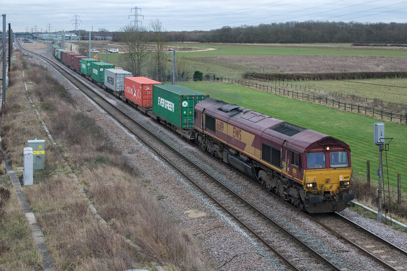 66119, 08.00 Felixstowe North-East Midlands Gateway (4M79, 10E), Marholm TF154036 
 The 4M79 08.00 Felixstowe to East Midlands Gateway intermodal service accelerates away from Peterborough past Marholm taking the Stamford line as it continues its journey north westwards. It never ceases to amaze me that there are still 'as-built' Class 66s, such as 66119 seen here, still operating with the company not being officially a freight operator since 13.11.07, nearing fifteen years ago! I suppose this is akin to the final few locomotives still running around in British Railways' green livery back in the early 1980s but there are a lot more of these Class 66s still about as there was back then. 
 Keywords: 66119 08.00 Felixstowe North-East Midlands Gateway 4M79 Marholm TF154036 EWS