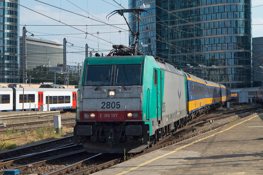 186 197, 17.45 Brussels Midi-Amsterdam Central (IC 9529), Brussels Nord station 
 SNCB 186 197 drifts into Brussels Nord station having just set out leading the IC 9529 17.45 Brussels Midi to Amsterdam Central. Notice the uniform rake of Dutch Railways coaching stock. I think that this colour combination looks very smart. 
 Keywords: 186 197 17.45 Brussels Midi-Amsterdam Central IC 9529 Brussels Nord station