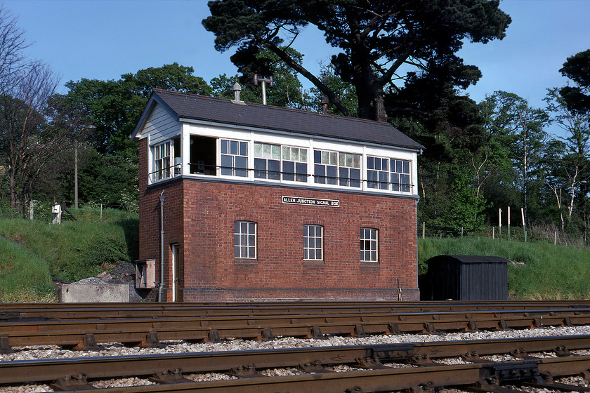 Aller Junction signal box (GW, 1925) 
 The superb 1925 Great Western signal box at Aller Junction is seen in the late afternoon sunshine. On a summer Saturday, the box would be a busy place controlling various services to and from Paignton as well as those going further to and from the West of England. The trick for down Plymouth/ Penzance workings was for the signalman to clear the down signal before the train departed from Newton Abbot and that he had obtained acceptance from Daignton box ensuring that it had reached line speed when passing the box so it had a good run at Daignton bank that commenced immediately after the junction with some fearsome gradients up to 1:34. The box was closed in 1987 but the frame lives on being recently installed in Broadway's 'new-build' signal box on the Gloucestershire and Warwickshire Railway, see... https://www.ontheupfast.com/p/21936chg/26925146604/broadway-signal-box 
 Keywords: Aller Junction signal box