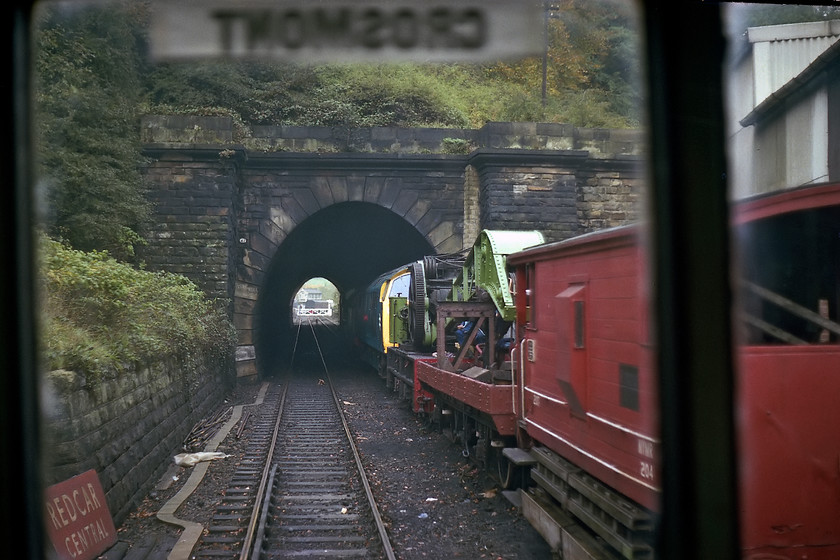 D1048, stabled, Grosmont Yard from class 100 DMU 
 Taken from the cab of class 100 DMU Sc50341 as it passes Grosmont yard on the North Yorkshire Moors railway. The image shows a brake van, a steam crane and D1048 'Western lady' half stabled in the short tunnel. Also notice, the ex BR (NE) tangerine enamel running-in sign from Redcar Central left laying by the track. 
 Keywords: D1048 Grosmont Yard class 100 DMU