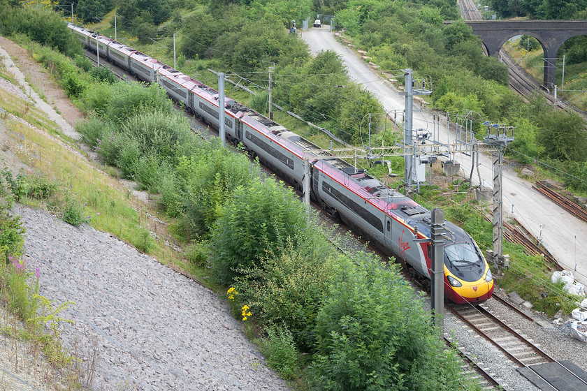 390042, VT 09.20 Manchester Piccadilly-London-Euston (1A07), Blisworth Road bridge 
 390042 'City of Bangor/Dinas Bangor' heads south approaching Roade Cutting taken from Blisworth Roid bridge. I am in a bit of a precarious position here with my ladder leaning against the bridge parapet with the busy and narrow road directly behind me. I always take three road traffic cones with me to this location to offer me a little bit of protection and I wear a hi-viz top; I do get some strange looks from motorists but at least they see me, slow down and drive around my ladder! 
 Keywords: 390042 09.20 Manchester Piccadilly-London-Euston 1A07 Blisworth Road bridge