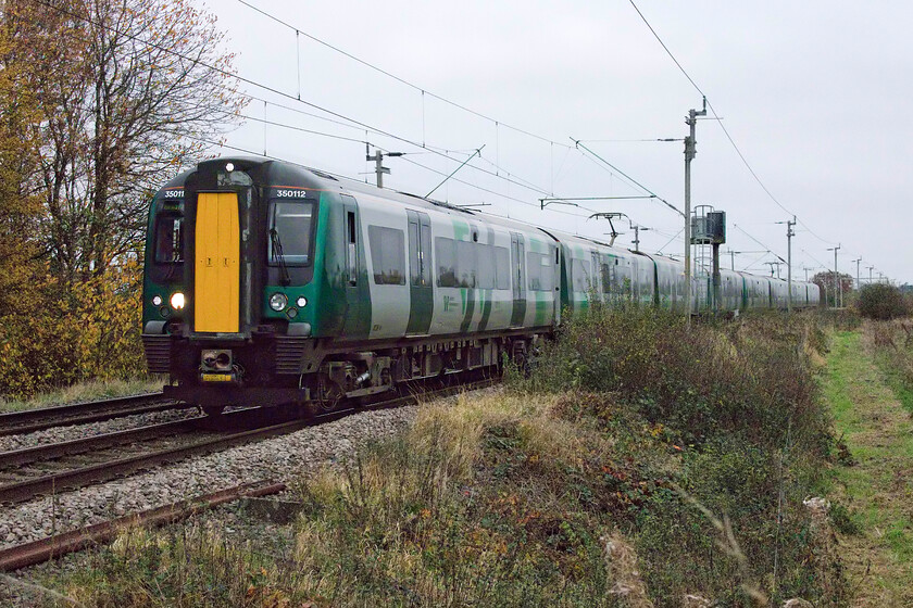 350112 & 350122, LN 08.14 Northampton-Birmingham New Street (2Y37, RT), Watford SP614688 
 Despite leaving Long Buckby station exactly one and a half miles to the south of this spot close to Watford village the Desiro has reached line speed and passes working the 08.14 Northampton to Birmingham all station stopper. Both the units working the train, 350112 and 350122, are from the original batch of Desiros introduced nearly fifteen years ago by Silverlink to replace the venerable, with apologies to the late Ted Rogers, Dusty Bins (Class 321)...where has that time gone? 
 Keywords: 350112 350122 08.14 Northampton-Birmingham New Street 2Y37 Watford SP614688 London Northwestern Desiro