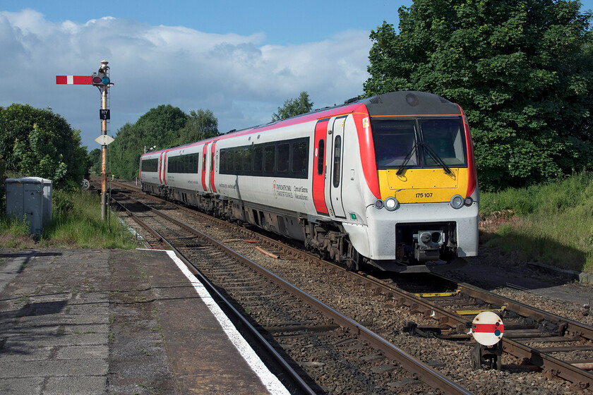 175107, AW 07.44 Llandudno-Manchester Airport (1H83, 1L), Helsby station 
 175107 approaches Helsby station in some early summer sunshine but the gathering wall of cloud to the southwest suggests that the weather is set to deteriorate! The 07.44 Llandudno to Manchester Airport Transport for Wales service is passing signal HY3 which is the down (Chester) starter. Notice also the disc signal permitting access to a couple of sidings now covered by trees off to the right of the train. 
 Keywords: 175107 07.44 Llandudno-Manchester Airport 1H83 Helsby station TfW Transport for Wales