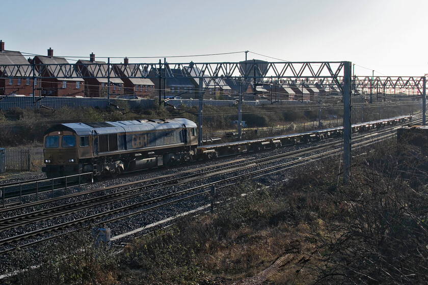 66758, 06.21 Ledburn Junction-Bescot Yard (6G63, 139L), site of Roade station 
 Whilst very welcome, winter sun can be very tricky as is the case here! 66758 'The Pavior' leads the 06.21 Ledburn Junction to Bescot Yard empty track train past Roade. This was the first of a number of returning infrastructure trains with this one being a mere two and a half hours late suggesting something went wrong during the New Year's Day possession between Cheddington and Tring. 
 Keywords: 66758 06.21 Ledburn Junction-Bescot Yard 6G63 site of Roade station GBRf The Pavior