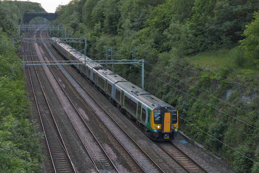 350127 & 350121, LN 17.05 Liverpool Lime Street-London Euston (9Y22, 5L), Hyde Road bridge 
 In the gloom of a summer's evening that should be a lot brighter than this, 350127 and 350121 pass through Roade cutting with the 17.05 Liverpool Lime Street to Euston service. Since the May timetable changes, direct trains between the two cities can be enjoyed from stations such as Northampton and Bletchley. 
 Keywords: 350127 350121 17.05 Liverpool Lime Street-London Euston 9Y22 Hyde Road bridge