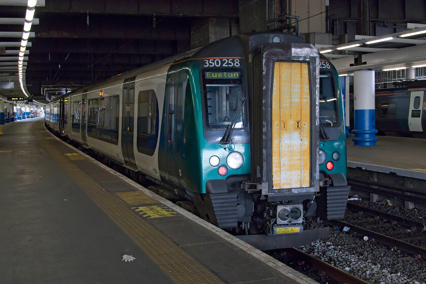 350258, LN 13.24 London Euston-Northampton (2N67, 1E), London Euston station 
 Our train home from Euston stands in the gloom of the station that will soon (in the next few years or so) be consigned to Brutalist history! 350258 leads another Desiro that will work the 13.24 Euston to Northampton 2N67 service that was relatively empty, long gone are the packed afternoon trains out of Euston with punters rushing down the platform to grab a seat! 
 Keywords: 350258 13.24 London Euston-Northampton 2N67 London Euston station London Northwestern Desiro