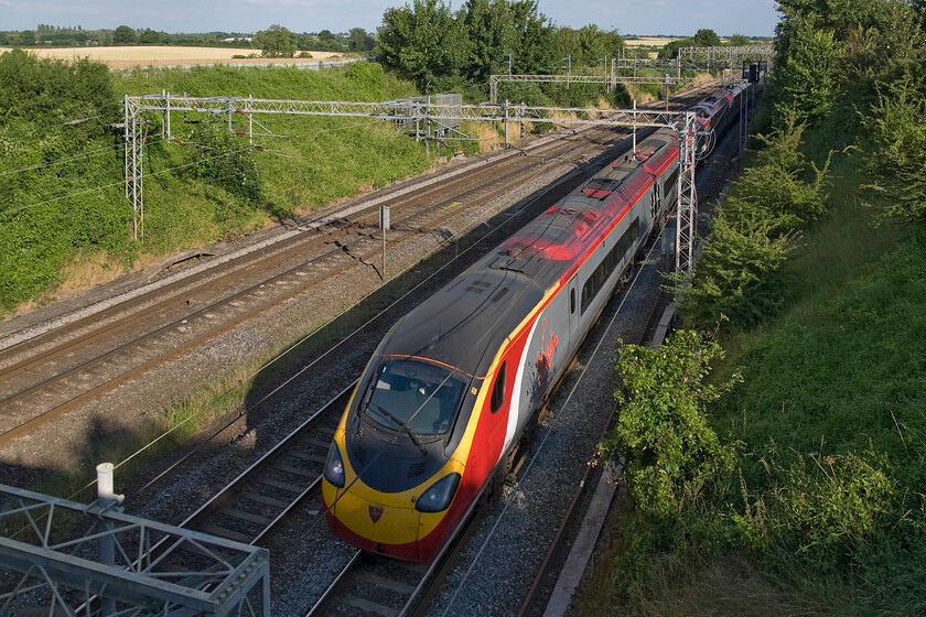 390046, VT 17.57 London Euston-Lancaster (1C94), Victoria bridge 
 The sun has just dropped a little lower in the sky so as not to quite illuminate the front of 390046 as it passes Victoria bridge just south of Roade. It is working the 17.57 Euston to Lancaster 1C94 Virgin West Coast service. 
 Keywords: 390046 17.57 London Euston-Lancaster 1C94 Victoria bridge Virgin Pendolino