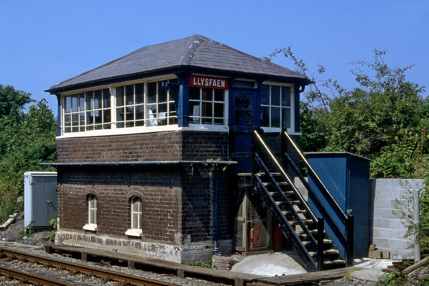 Llysfaen signal box (LNW, 1868) 
 A particularly early example of a L&NWR signal box is seen standing in the balmy summer sunshine at Llysfaen on the North Wales coast. Research identifies some debate over the date of construction varying from 1868 to 1870 but there is agreement that it was a Saxby and Farmer construction that had its original frame changed to a L&NWR standard tumbler example in 1902. When this photograph was taken it was switched out which seemed pretty common at the time with it closing just two years later in 1983. Another factor that may well have led to its demise was that the new A55 North Wales coast road was shoehorned in between the coastline and the railway directly behind the box with a huge bridge crossing the line at about this spot. 
 Keywords: Llysfaen signal box L&NWR