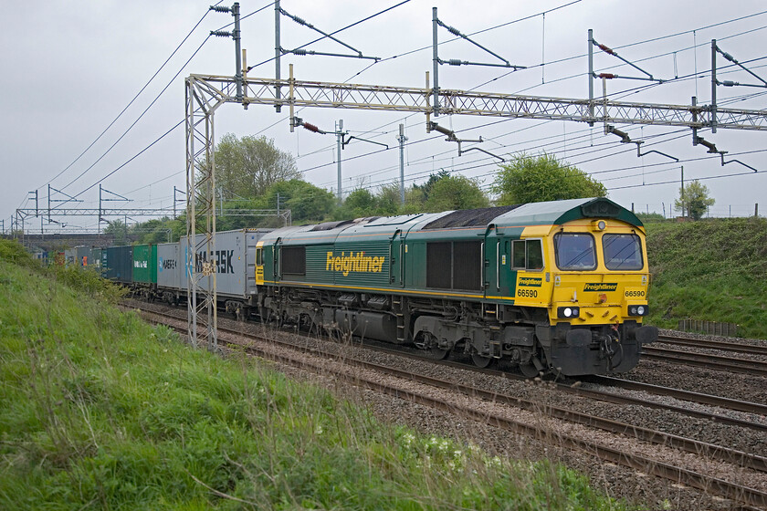 66590, 03.51 Felixstowe South-Lawley Street (4M88), Roade Hill 
 The 4M88 03.51 Felixstowe South to Lawley Street (Birmingham) Freightliner approaches Roade led by 66590. Whilst this particular spot is perfect for photographing up workings, as can be seen here, capturing down services is not so easy given the embankment to the left. 
 Keywords: 66590 03.51 Felixstowe South-Lawley Street 4M88 Roade Hill Freightliner