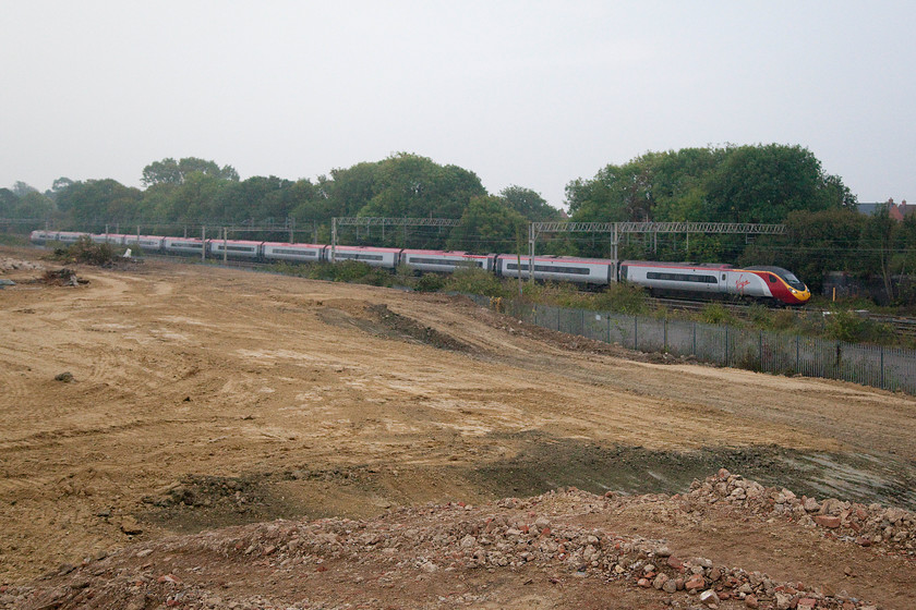 Class 390, VT 07.03 London Euston-Birmingham New Street (9G04), site of Roade station 
 The demolition and lanscaping of the former Pianofort site in Roade has afforded some new views of the WCML, but not for long, as soon a substantial housing estate will be filling the site. A class 390 passes the flattened site with the 07.03 Euston to Birmingham New Street. 
 Keywords: Class 390 07.03 London Euston-Birmingham New Street 9G04 site of Roade station