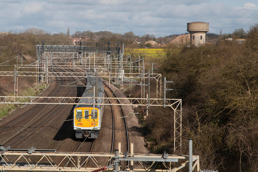 319429 & 319457, LM 09.24 Bletchley CS-Northampton EMUD ECS (5N19), Victoria bridge 
 319429 brings up the rear of the 09.24 Bletchley CS to Northampton Kingsheath EMU depot ECS stock move. The train is seen passing Victoria bridge just south of Roade on the WCML. In the background is one of Roade's two water towers. Behind the water tower is is the remains of the Pianoforte factory that is in the process of being demolished to make way for a huge and unpopular housing development. The giant mounds are chopped up concrete from the demolition of the factory buildings. 
 Keywords: 319429 319457 09.24 Bletchley CS-Northampton EMUD ECS 5N19 Victoria bridge