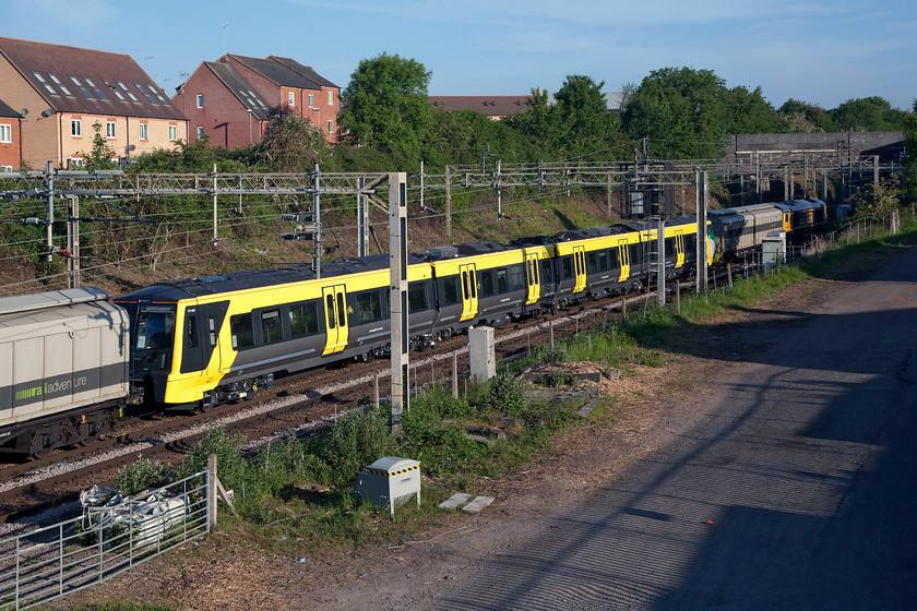 777007 & 66715, 02.44 Dollands Moor-Kirkdale (6X29, 15E), site of Roade station 
 A closer view of 777007 being dragged as the 02.44 Dollands Moor to Kirkdale as it passes the site of Roade station. My feeling is that these new Merseyrail units look more like trams than trains but what's in a word, they still do the same thing! The unit and a small selection of barrier wagons are being dragged by 66715 'Valour' that is just in frame at the front of the train. 
 Keywords: 777007 66715, 02.44 Dollands Moor-Kirkdale 6X29 site of Roade station Stadler Valour