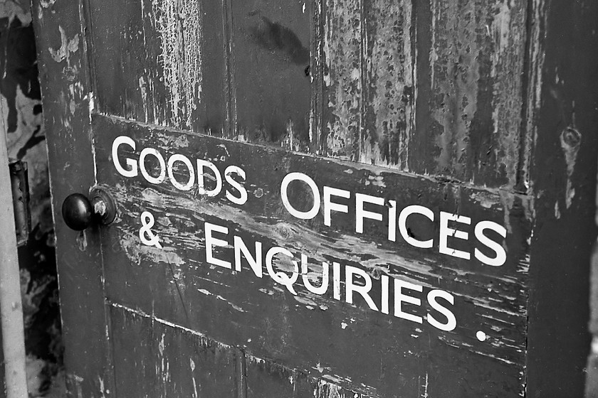 Door and writing, former Trowbridge goods shed 
 Unfortunately in this black and white image, the colour of the somewhat cracked and aged paint on the former goods office door cannot be seen but it would have been a rather faded version of the Great Western's brown. I suspect that the wiring on the door would have been hand-painted. The goods shed at Trowbridge was still standing and being used as part of the station car park but was demolished in act of licensed and wanton vandalism during 1984 when the whole area was tarmacked to become the extended station car park. 
 Keywords: Door and writing former Trowbridge goods shed