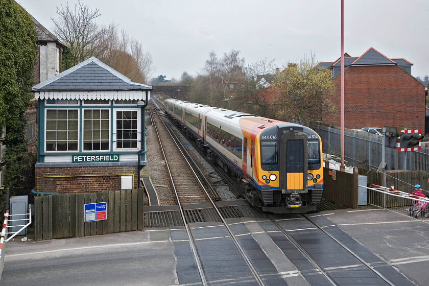 444016, SW 12.00 London Waterloo-Portsmouth Harbour, Petersfield station 
 Passing Petersfield's superb Victorian signal box the 12.00 Waterloo to Portsmouth Harbour slows for its stop worked by 440016. At fifty-four miles from Waterloo it enjoys regular services to the capital and is particularly busy during the morning and evening commute. I suspect that the residents of the town are not so keen on these regular services as the crossing gates are down for some length of time during the average hour. 
 Keywords: 444016 12.00 London Waterloo-Portsmouth Harbour Petersfield station SWT