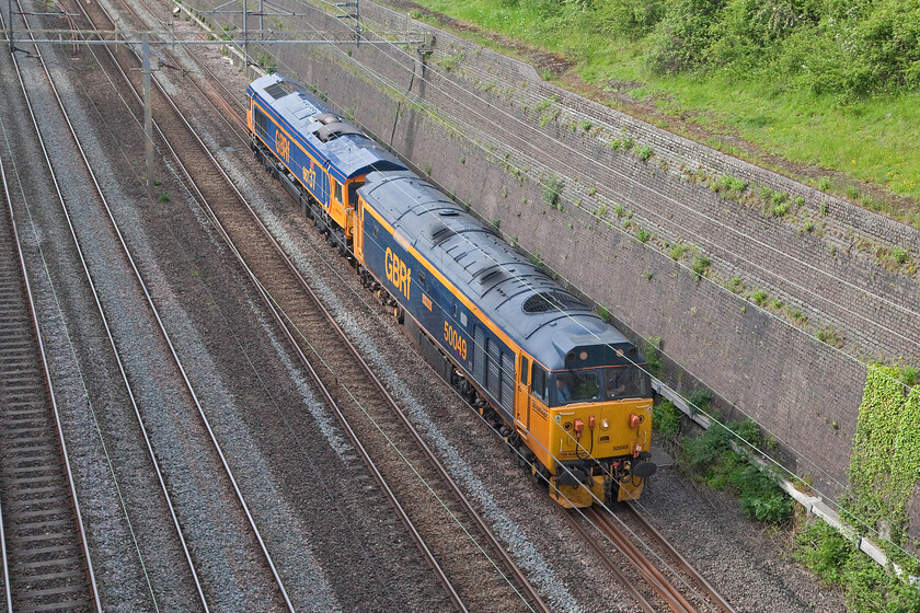 50049 & 66737, 15.06 Kidderminster SVR-Stewart's Lane (0Z60, 2E), Roade cutting 
 A duo of GBRf motive power that is decades apart sweep through Roade cutting in a welcome burst of afternoon sunshine. 66737 'Lesia' dates from 2003 whilst 50049 'Defiance' from 1968 but both look equally smart in their GBRf liveries. The two locomotives were heading south as the 15.06 Kidderminster to Stewert's Lane 0Z60 working in order to take up charter duties the following day. 
 Keywords: 50049 66737 15.06 Kidderminster SVR-Stewart's Lane 0Z60 Roade cutting GBRf Defiance 	Lesia