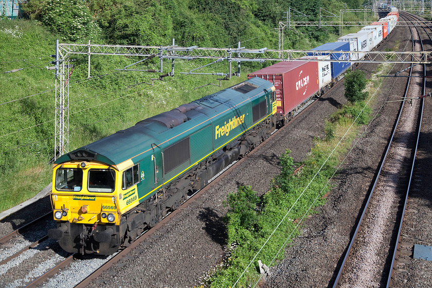 66569, 05.47 Trafford Park-Felixstowe North (4L97), Victoria Bridge 
 66569 brings the 4L97 05.47 Trafford Park to Felixstowe Freightliner past Victoria Bridge just south of Roade. The eagle-eyed almost you will spot that it's on the up fast having travelled via the Weedon loop. All trains were being diverted to use this route as the Northampton line was closed due to an 'emergency incident' somewhere north of the town. As would be expected, on a busy Saturday morning, this and many other diversions, created a challenge for control and caused many minutes of delays to all services. 
 Keywords: 66569 05.47 Trafford Park-Felixstowe North 4L97 Victoria Bridge