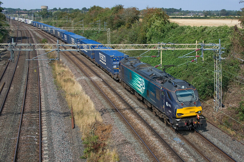 88002, 12.41 DIRFT-Tilbury (4L48, RT), Victoria bridge 
 The Sunday up Tesco Express passes Victoria bridge just south of Roade. Running seven days a week the 4L48 12.41 Daventry to Tilbury is led by DRS' 88002 'Prometheus'. I only just managed to get this photograph arriving just twenty seconds or so before it appeared around the curve in the distance due to getting caught up in a mass of brambles and nettles on my walk from home; I must bring my trimmers next time to clear the path! 
 Keywords: 88002 12.41 DIRFT-Tilbury 4L48 Victoria bridge DRS Prometheus