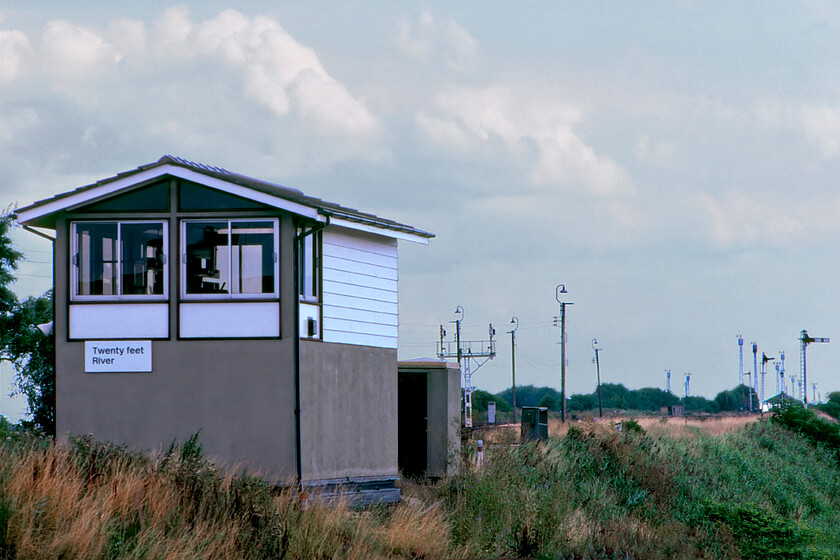 Twenty Feet River signal box (BR, 1974) 
 The first box of the GN & GE JR (the Joint March to Spalding line) as it left March was the oddly named Twenty Feet River. Located at the very northern end of Marchs vast Whitemoor Yard it was a relatively new box being opened by BR in 1974 replacing the former Great Eastern box named Twenty Feet Siding that was subsiding into the soft Fenland soil. The replacement box would only be in use for eight years closing when the Joint line was shut in 1982. This spot can still be visited today as a footpath passes the sight of the box following the route of the railway into Whitemoor and forms part of the National Cycle Network's Route 63. I stood in a very similar spot in 2023 in an attempt to replicate this photograph, see.https://www.ontheupfast.com/p/21936chg/30044473937/site-twenty-feet-river-signal-box 
 Keywords: Twenty Feet River signal box British Railways