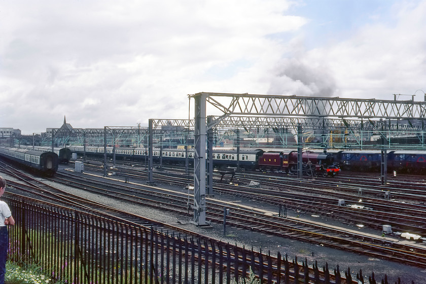 5690, BR sponsored Manchester-Liverpool Edge Hill Special, Edge Hill 
 5690 'Leander' is seen in Edge Hill yard in amongst, much stock and various wagons. I suspect that this was the first time that the former LMS Jubilee had been in the yard for many years since its initial withdrawal in 1964. Up to then, it would have been a regular visitor leading express' to and from nearby Liverpool Lime Street. This view is not possible of the now much-reduced yard located just east of Edge Hill station near to the Wavertree Road bridge. This early type of palisade fencing has now been replaced by the more normal taller variety and the bank on which I am standing is completely inaccessible.

There is an audio recording of this event on my youtube channel, see..https://youtu.be/dC3Vdy6E4t8 
 Keywords: 5690 BR sponsored Manchester-Liverpool Edge Hill Special Edge Hill Leander LMS 45690 Jubilee