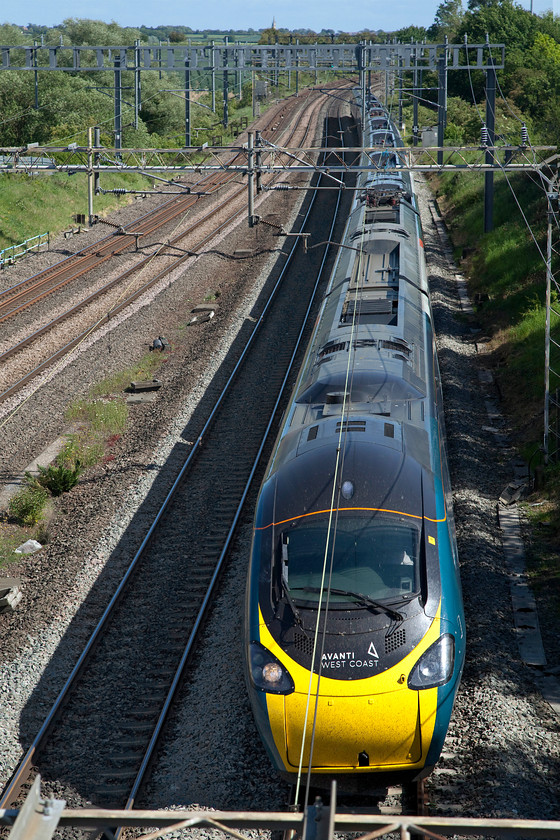 390156, VT 15.08 London Euston-Warrington Bank Quay (1S78, 5E), Ashton Road bridge 
 Wearing its Avanti West Coast livery 390156 'Pride and Prosperity' races on the down fast past Ashton Road bridge just south of Roade working the 15.08 Euston to Warrington Bank Quay. Whilst the train carries the reporting number of 1S78 it is terminating at Warrington due to engineering works somewhere north of the Cheshire town including a complete closure of the line in the Borders. 
 Keywords: 390156, VT 15.08 London Euston-Warrington Bank Quay (1S78, 5E), Ashton Road bridge Avanti West Coast Virgin Pride and Prosperity