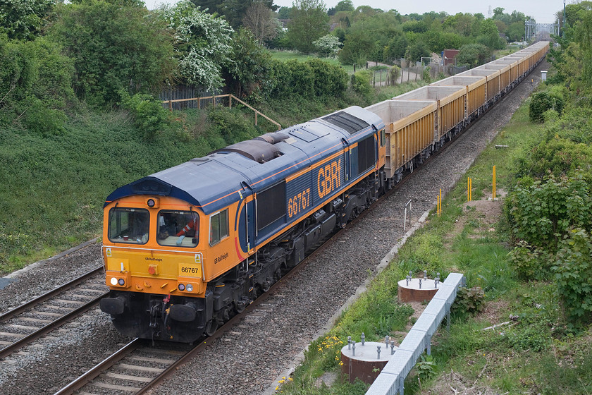 66767, 11.56 Westbury-Cliffe Hill Stud Farm (6M40), Steventon 
 GBRF 66767 passes Steventon just west of Didcot with the 11.56 Westbury to Cliffe Stud farm empty stone wagons. Notice in the foreground the bases for the electrification masts that will ruin this photographic position. Whilst electrification is an inevitable part of railway modernisation it does nothing for photographic opportunities! 
 Keywords: 66767, 11.56 Westbury-Cliffe Hill Stud Farm 6M40 Steventon