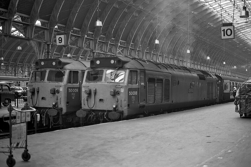 50008, unidentified up working & 50009, 15.20 Bristol Temple Meads-London Paddington (1A19), London Paddington station 
 Consecutively numbered 50008 'Thunderer' and 50009 'Conquerer' stand at Paddington's platforms nine and ten. Whilst I have been unable to work out what service 50008 had worked in from the West Country, 50009 had led the 1A19 15.20 ex Bristol Temple Meads. Whilst the two locomotives are the centrepiece of the photograph there is much else of interest. Back in 1981 taxis and other vehicles could access the wider spaces between the platforms making the onward journey for some passengers much more straightforward. In addition, notice the exhaust haze looking towards the light in the station's arch and finally, the fully loaded mail trolley to the extreme right. 
 Keywords: 50008, unidentified up working & 50009, 15.20 Bristol Temple Meads-London Paddington (1A19), London Paddington station Thunderer Conquerer