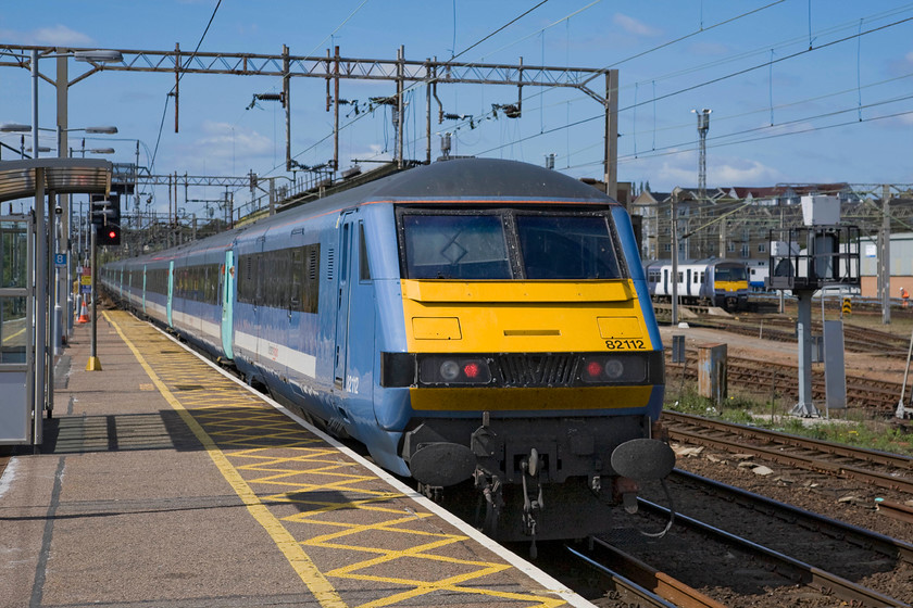 82112, LE 12.00 Norwich-London Liverpool Street (1P35) & Class 321, stabled, Colchester station 
 Until new stock is procured, constructed, tested and introduced the travelling public on the Great Eastern Mainline will continue to make use of Mk. III stock that is over thirty years old! A rake of the stock leaves Colchester station with the DVT trailing along at the rear as the 12.00 Norwich to Liverpool Street. This rake of stock still wears the older livery of Greater Anglia awaiting a visit to the paint shop to receive its revised Abellio white paint scheme. 
 Keywords: 82112 12.00 Norwich-London Liverpool Street 1P35 Class 321 Colchester station