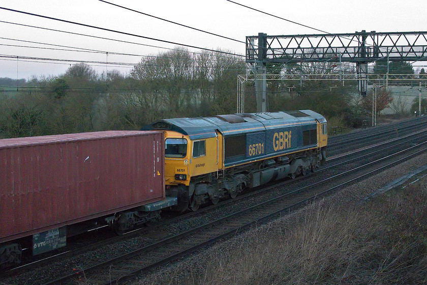 66701, 03.10 Felixstowe North-Trafford Park (4M21), Roade Hill 
 Now this was a real test for the newish Canon G1X Mk. III camera! It wasn't even half light really and I needed at least 1/1200 sec. to capture the 03.10 Felixstowe to Trafford Park 4M21 Freightliner. The camera needed 12 800 ISO that obviously produced a noisy image. However, after a little Photoshop fettling and the use of the superb add-on produced by Neat Image.... https://ni.neatvideo.com a passable picture was produced. 66701 is seen leading the train past Roade Hill just south of the village of the same name on the WCML. 
 Keywords: 66701 03.10 Felixstowe North-Trafford Park 4M21 Roade Hill