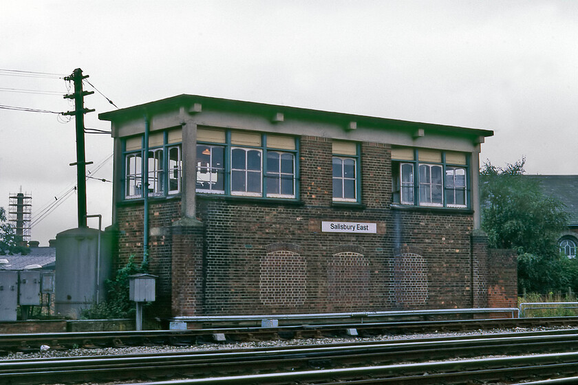 Salisbury East signal box (LSW, 1902) 
 A decent photograph of Salisbury East signal box was always a tricky proposition due to its location deep in the East Yard. However, not for me on this Saturday morning wearing my orange BR issues tabard meaning that I could wander around with impunity! When this photograph was taken the box had just eleven days in use before being replaced by a panel box unusually located behind an anonymous door on Salisbury station's platform four. The East box (like its West brother) had a 'draw-slide' power lever-frame, which worked all the signals and points by means of low-pressure air. The head of air was kept in the large vertical tank seen to the left of the box. It's a shame that the look of the 1902-built L&SWR box has been marred by the rather crude infilling of the lower windows. 
 Keywords: Salisbury East signal box LSW 1902