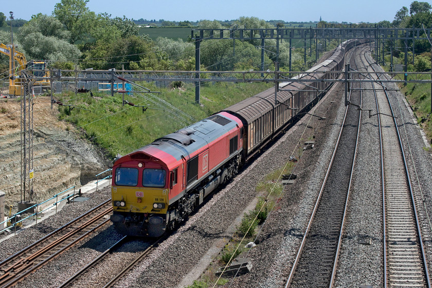 66128, 07.05 Dollands Moor-DIRFT (6M45, 2L), Ashton Road bridge 
 Under intense blue skies with not a cloud in sight, 66128 leads the 07.05 Dollands Moor to Daventry bottled water train past Ashton Road bridge just south of Roade. With such strong overhead lighting and looking south-east during the middle of the day makes for very tricky photographic conditions as illustrated here. 
 Keywords: 66128 07.05 Dollands Moor-DIRFT 6M45 Ashton Road bridge DB