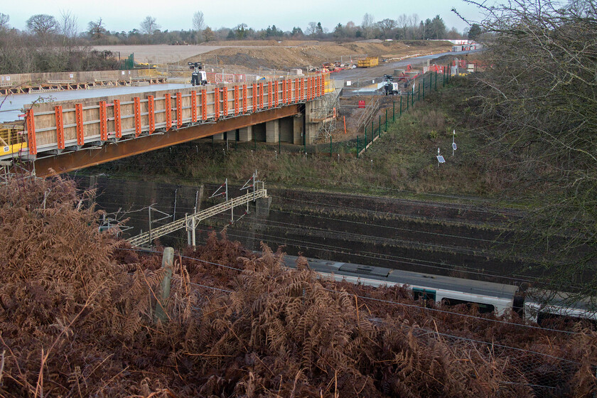 Class 350, LN 10.55 London Euston-Birmingham New Street (Cancelled from Birmingham International) (1Y29, 2L), Roade cutting 
 By the end of 2023, the new bridge seen here spanning Roade cutting should be carrying traffic away from Roade's busy village, bringing its residents relief. An unidentified Class 350 Desiro can just be seen passing under the bridge deep in the cutting. Once access to the bridge is permitted it will be interesting to see what new perspectives it will offer the railway photographer but I suspect that a stout pair of steps will be a requirement! 
 Keywords: Class 350 10.55 London Euston-Birmingham New Street Cancelled from Birmingham International 1Y29 Roade cutting A508 London Northwestern Desiro