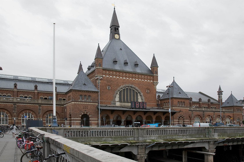 Frontage, Copenhagen Central station 
 The elegant frontage of Copenhagen Central station is seen against a very grey sky. The station sits atop the platforms with access to the platforms either side of a long and wide concourse. The station has undergone a number of refurbishments and expansions over the years. This process is set to continue with a dramatic expansion planned for the next decade. I wonder wif, when this happens, that the rather unusual and out of character digital clock will be changed? 
 Keywords: Frontage Copenhagen Central station