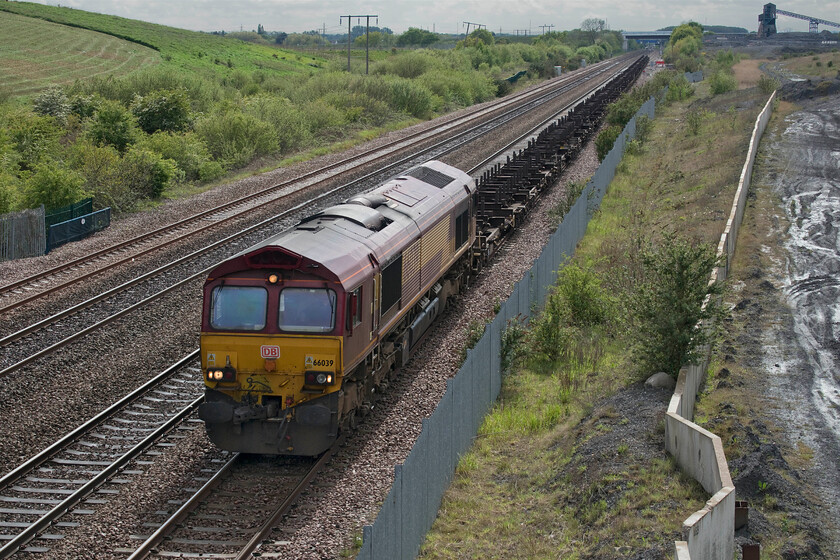 66039, 08.09 Dollands Moor-Scunthorpe Redbourn (4E26, RT), Cuckoo bridge SE660116 
 To the right in this photograph at Stainforth, there were once a number of lines following the path of the concrete reinforcement panels that led towards the coal mine loading point that can be seen on the skyline. 66039 leads the 08.09 Dollands Moor to Scunthorpe Redbourn empty steel flats working as it closes in on its destination. The train was progressing at a little more than walking pace as the driver was anticipating getting the feather at Thorne Junction without having to bring his train to an actual halt; unfortunately, the signalman had other ideas! 
 Keywords: 66039 08.09 Dollands Moor-Scunthorpe Redbourn 4E26 Cuckoo bridge SE660116 EWS