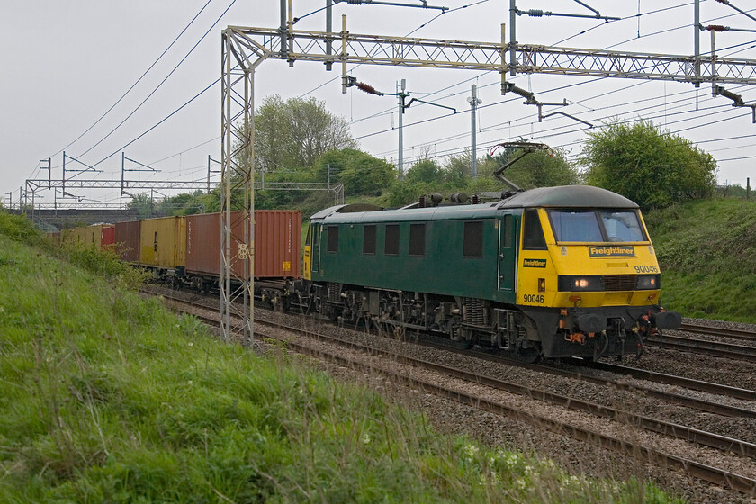 90046, 03.09 Felixstowe North-Ditton (4M45), Roade Hill 
 90046 leads the 03.09 Felixstowe to Ditton Freightliner between Roade and Ashton in Northamptonshire. Apart from its in-house green paint scheme the Freightliner Class 90 has minimal branding with relatively small vinyls on the nose and cabsides. 
 Keywords: 90046 03.09 Felixstowe North-Ditton 4M45 Roade Hill Freightliner