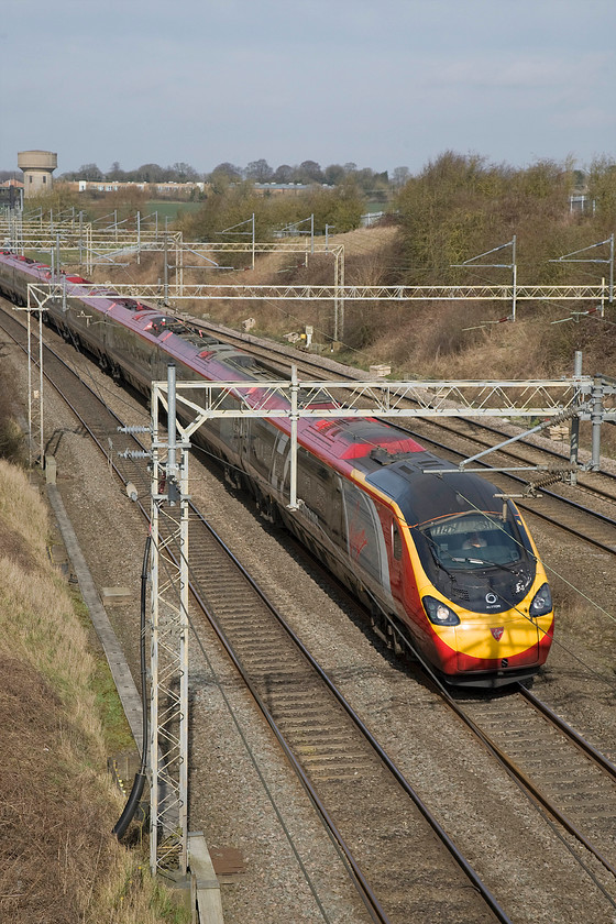 390104, VT 06.34 Glasgow Central-London Euston (1M07), Victoria bridge 
 Virgin Trains' 390104 'Alstom Pendolino' sweeps around the curve under Victoria bridge located just south of Roade in Northamptonshire. This is the first up Anglo-Scottish express of the day having left Glasgow at 06.34 running as 1M07. 
 Keywords: 390104 06.34 Glasgow Central-London Euston 1M07 Victoria bridge